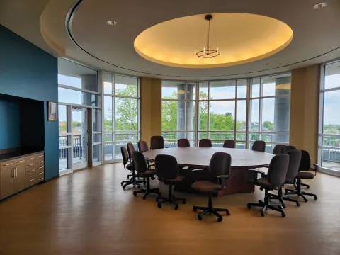 25 person round table in a room with floor to ceiling windows